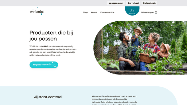 Winbiotic is presented with a clean landing page featuring a Dutch headline “Producten die bij jou passen” and a teal call-to-action button “Bekijk ons assortiment,” alongside a rounded photograph of a cheerful family outdoors in a garden, illustrating the brand’s focus on personalised bacterial strain combinations.