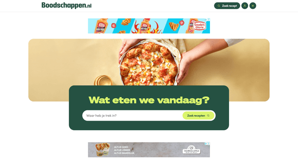 Boodschappen.nl is a Dutch recipe website whose homepage features a prominent hero section on a warm beige background, showing a close-up of hands holding a pizza topped with salmon or ham and melted cheese. Centered over the image is a dark-green panel with large yellow text asking “Wat eten we vandaag?” and a bright lime-green “Zoek recepten” button for searching recipes.